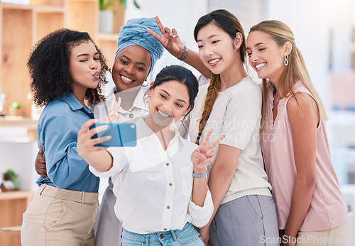 Image of Fun, diverse and playful team selfie on phone and having fun, goofing around or making peace sign gesture. Cheerful goofy group of business friends or creative colleagues posing for social media post