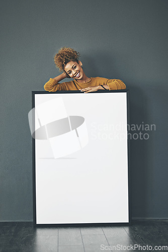 Image of A beautiful confident woman holding a blank whiteboard or billboard sign with copy space. Happy and attractive female with a smile standing behind a banner. Young lady advertising with a poster