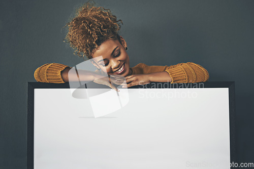 Image of Woman holding blank poster, copy space board and placard sign to promote, market and advertise opinion or voice on female empowerment. Smiling, young and happy lady endorsing with billboard in studio