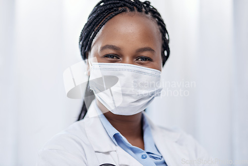 Image of Doctor wearing hygiene face mask for covid, safety and precaution in the healthcare industry. Portrait and face of confident black medical practitioner and coronavirus frontline worker in a hospital