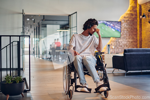 Image of A sad businessman in a wheelchair occupies a hallway within a modern startup coworking center, embodying inclusivity and determination in the business environment