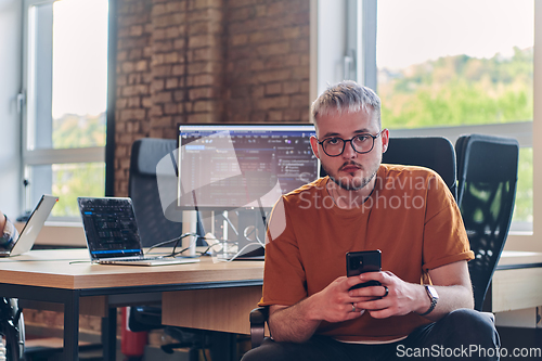 Image of A modern businessman takes a relaxing break from work, using his smartphone to unwind and recharge during his pause