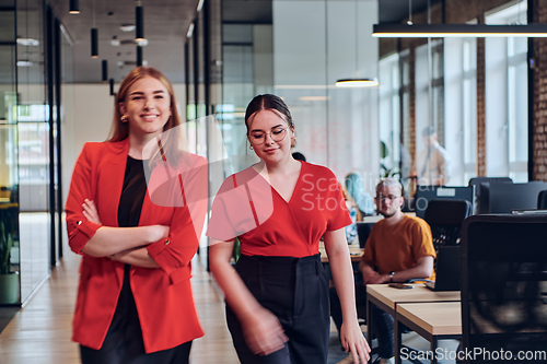 Image of Group of determined businesswomen confidently pose side by side in a modern startup coworking center, embodying professionalism and empowerment