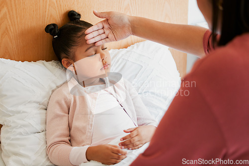 Image of Sick child with mother checking forehead temperature, feeling ill and unwell. Small girl with illness, fever or disease at home in bed resting, sleeping and recover from infection, flu or covid virus