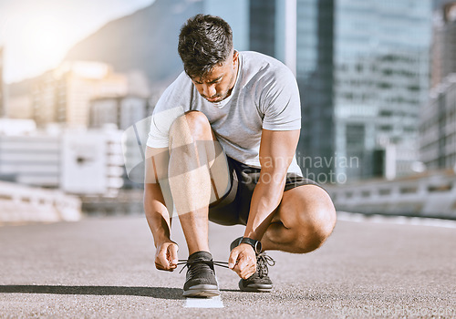 Image of Wellness and fitness runner ties shoes lace before running in a city street during summer. Healthy man athlete prepare sneaker for a comfortable fit for a sport exercise, training or marathon workout