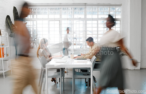 Image of Blurred designers, marketing or freelance professionals working together in a modern office. Business men and women busy, walking and active in a creative workplace, workstation or environment