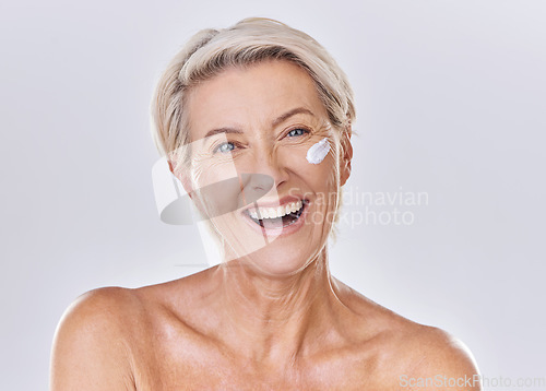 Image of Senior woman skin care, sunscreen and face wash or cream on skin with happy looking portrait in a studio. Skincare, clean and hygiene of elderly lady for wrinkles free aging or antiaging moisturizer
