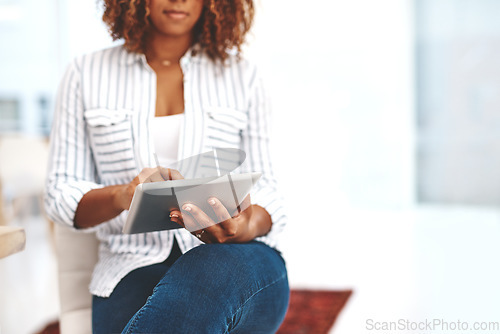 Image of Female holding a tablet, scrolling the web online and social media at home. Casual woman checking emails and taking a break on the internet. Lady using modern technology to relax inside