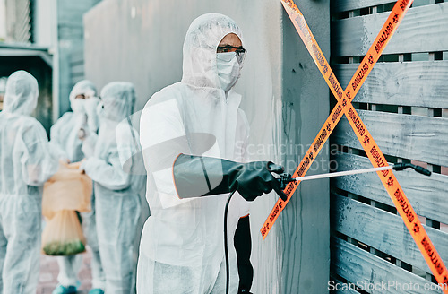 Image of Hazmat wearing medical and healthcare worker sanitizing and cleaning a quarantine and contamination site. Medical professional stopping the spread of a virus or infection of a building in the city