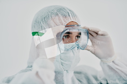 Image of Healthcare worker wearing protective hazmat suit during covid virus outbreak. Medical research professional in a quarantine zone preparing for sanitizing and staying safe during pandemic restrictions