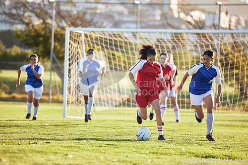 Image of Sports team, girl soccer and kick ball on field in a tournament. Football, competition and athletic female teen group play game on grass. Fit adolescents compete to win match at school championship.