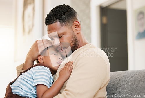 Image of Sleeping and tired child with caring father holding his sleepy son on a home lounge sofa. Worried dad hugging his young boy resting on a living room family couch indoors feeling stress and worry