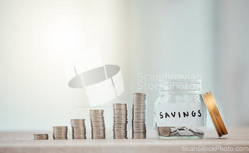 Image of Finance, budget and saving money or coins by depositing currency, cash and pennies in a glass jar on copy space background. Closeup of piled, stacked and heaped cents for planning or future investing