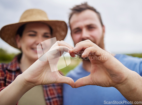 Image of Farmer couple support sustainability by making a love heart sign with their hands outdoors on an organic farm. Happy and carefree activists with a passion for sustainable and organic farming