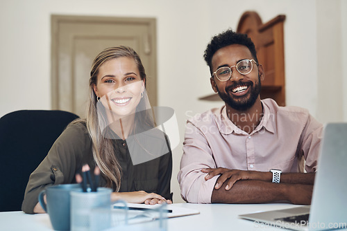 Image of Happy diverse employees working together on a project sitting in an office table satisfied with the partnership. Portrait of young colleagues with a positive mindset smiling about business growth