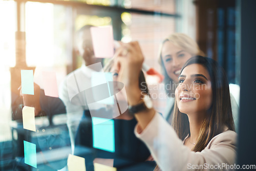 Image of Team leader planning and writing on sticky notes while showing innovation, sharing a vision and ideas. Diverse group of creative office business people meeting together to market new startup company