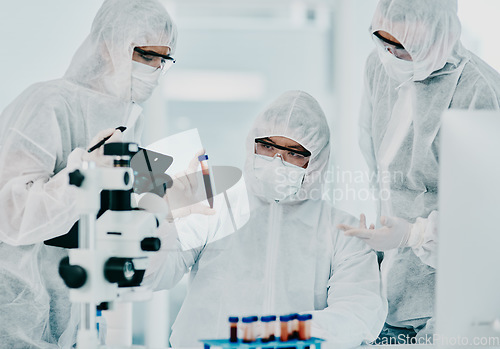 Image of Hazmat suit scientists with test tube in medical research, healthcare or science cure testing for covid, marburg virus or ebola. Group of laboratory professionals looking or checking DNA blood sample