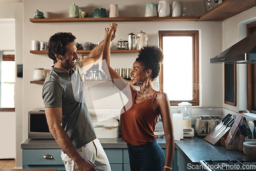 Image of Happy, in love and dancing while an interracial couple have fun and enjoying time together in home kitchen. Husband and wife sharing a dance while being active and affectionate in loving relationship