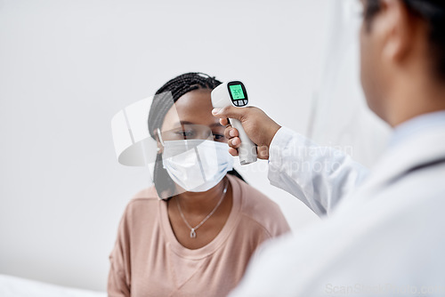 Image of Doctor taking temperature of a covid patient while testing for high fever symptoms of sick, flu or illness. Screening woman for a healthcare consult, checkup and visit in a hospital or medical clinic