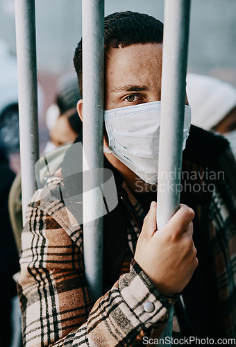 Image of Sick, refugee of a young covid patient in quarantine to cross the border with a medical face mask. Foreign man in a prison crowd during a pandemic following healthcare safety rules of the virus.