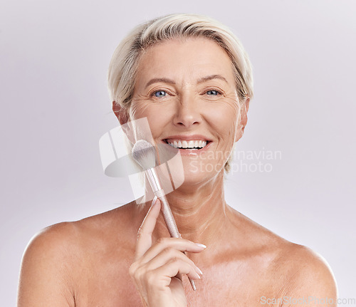 Image of Beauty, skincare and makeup with a senior woman applying cosmetics to her face in studio against a purple background. Head portrait of a female with blusher looking beautiful, happy and healthy