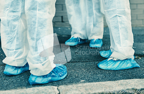 Image of Legs and feet of healthcare workers wearing protective gear or hazmat suits outdoors while cleaning. Closeup of a team of medical professionals meeting during the covid or coronavirus pandemic