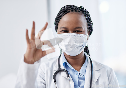 Image of Doctor gesturing okay hand sign, symbol and emoji to express success and agreement in a good clinic or hospital. Portrait of a smiling medical pathologist looking happy after finding a cure for covid