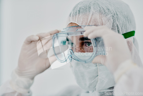 Image of Covid, pandemic of young man putting on his protective gear for health and safety from the virus. Serious professional infection fighter ready to combat the spread of the disease or illness.