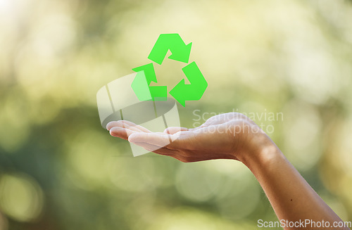 Image of Hand, closeup recycle sign isolated with bokeh effect background. Zero waste, ecology and environmental symbol for sustainable living. Clean and eco friendly habits to protect and save the earth.