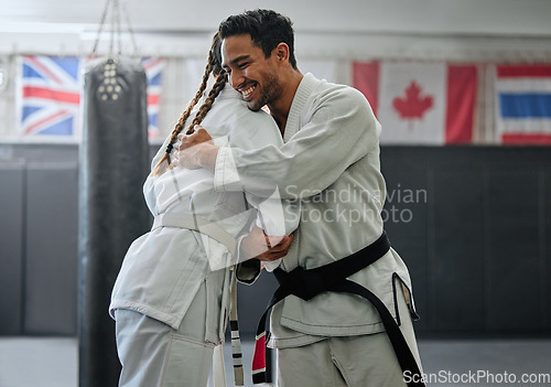 Image of . Karate trainer giving hug to female student for motivation, coach embracing for support and celebration after winning competition. Teammates and friends training and learning martial arts at a gym.