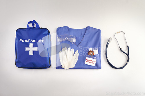 Image of Medical kit, doctor scrubs and hospital equipment on a table for safety and healthcare in a clinic from above. Flat and top view of a bag, uniform and stethoscope on a desk before a procedure