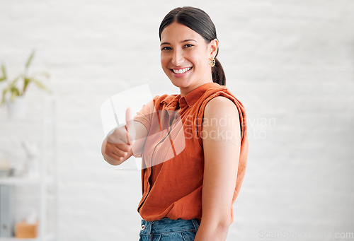 Image of Positive young woman treated with covid vaccine injection, gestures thumbs up and showing her arm to approve immunization. Happy healthy female patient wearing bandaid after her treatment shot