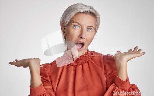 Image of Mature surprised, wow and shocked woman face against a grey copy space grey studio background posing with her hands up and feeling unsure. Portrait of senior model making facial expression or emotion