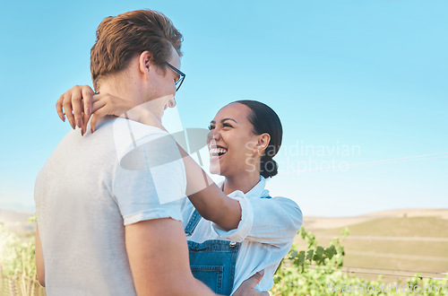 Image of Laughing, in love and happy interracial couple in hug, embrace or holding each other on wine tasting farm. Fun, playful or loving man and woman standing close and enjoying countryside vineyard estate