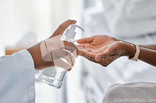 Image of Doctor giving patient hand sanitizer for protection, hygiene and bacteria disinfection in covid pandemic, protocol and virus. Healthcare safety and cleaning hands to prevent flu, corona and illness