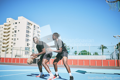 Image of Basketball, sports and game between sporty male players having fun while playing on a court outdoors. Young black friends training and being active together while competing in a competitive sport