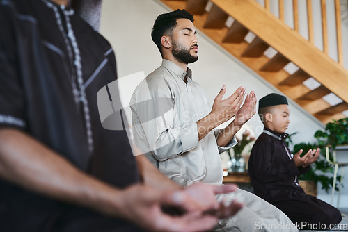 Image of Muslim family praying together at home with eyes closed during fajr, dhuhr, asr, maghrib or Isha. Practicing religion and cultural tradition to serve or worship the god of their faith and belief