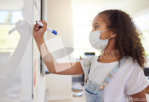 Image of Smart, clever and intelligent girl writing an answer on a whiteboard at elementary school during the covid pandemic. Child development or quality education for a young kid learning in class
