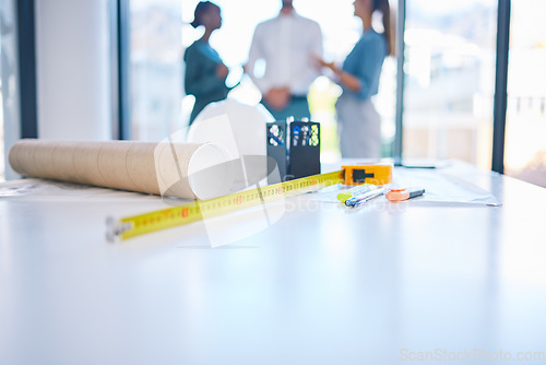 Image of Architecture, construction and building with plans, blueprints and tape measure on a desk in an architect office. Closeup of engineer or contractor equipment on a table ready for planning and design