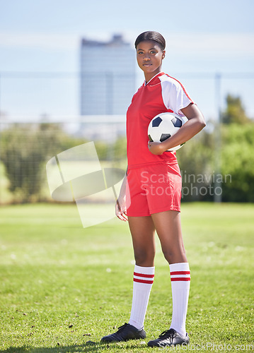 Image of Strong and confident soccer football female player with ball for practice and training on sports field. Portrait of determined and competitive woman in sport kit ready for game or match to start