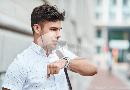 Image of Chatting on a smartwatch with a young creative business man or intern commuting in the city. Hailing a cab, taxi or ride with an app on wireless technology. Male employee travelling to and from work