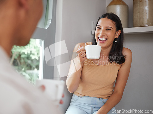 Image of Happy, carefree and laughing woman drinking coffee in the morning and having fun with her boyfriend at home. Young and excited female laughs at a funny joke while and enjoying time with her partner