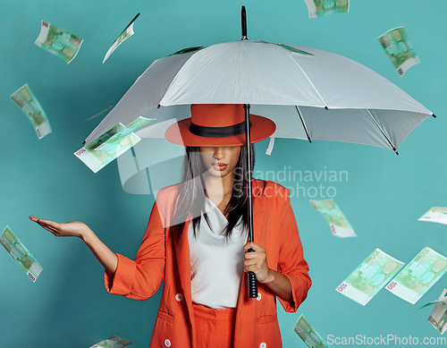 Image of Money, fashion and rich lady being showered by cash while holding umbrella for insurance, protection and cover showing her wealth after payout. Winning luxury woman with dollar bills in the air