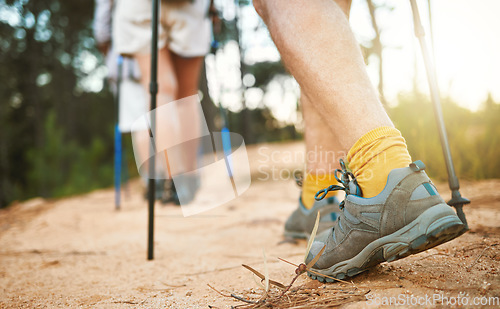 Image of . Feet or shoes walking, trekking and hiking on a trail up a mountain with sticks and poles. Closeup of group of adventurous hikers or friends exploring rugged path on a mountain in nature.