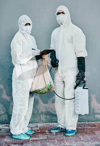 Image of Scientists disinfect isolated and dangerous area. Medical staff protect themselves with sterile equipment. Healthcare workers clean while wearing safety uniform to stop the spread of a virus.