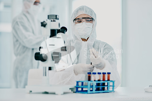 Image of A scientist conducting a medical experiment to research covid vaccine in a lab and collecting blood samples. Healthcare researcher analyzing chemicals in a chemistry laboratory wearing a hazmat suit