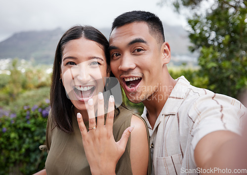 Image of Engagement, ring and celebration with a young couple announcing their happy news and special occasion. Closeup portrait of a man and woman taking a selfie after getting engaged to be married outside