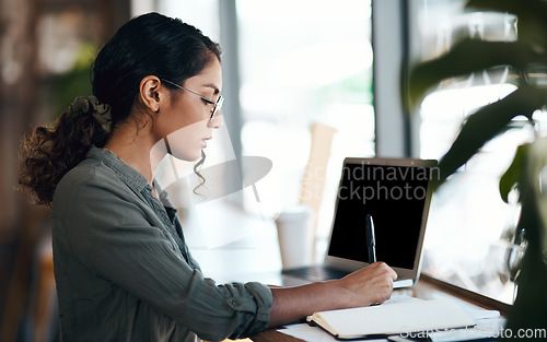 Image of Writing, serious and freelance young woman working with laptop and notebook at a cafe. Creative remote worker or female student planning, brainstorming a mind map about future career.