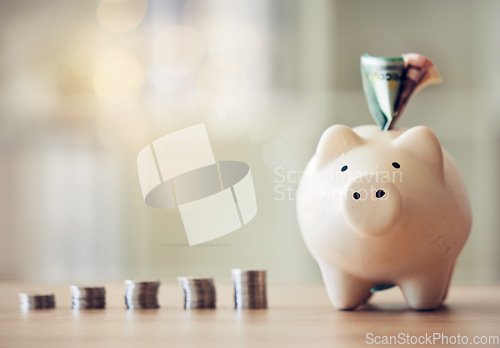 Image of . Banking, accounting and financial management to plan for the future, collect a rainy day fund and profit. Piggybank, saving and finance with money, coins and cash in a coin bank on a table at home.