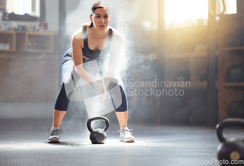 Image of Fitness kettlebell and gym woman with chalk on hands during weightlifting workout, exercise or training. Athletic, active and strong girl exercising with weight equipment to build muscle strength